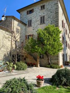 a large stone building with a tree in front of it at Agriturismo Del Casato in Sansepolcro