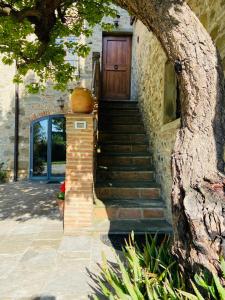 a stone house with a wooden door and stairs at Agriturismo Del Casato in Sansepolcro