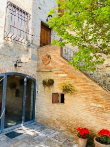 a brick building with a staircase and flower pots at Agriturismo Del Casato in Sansepolcro