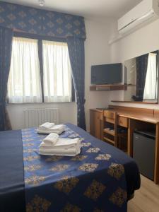 a hotel room with a bed with towels on it at Hotel Merloni in Grandola ed Uniti