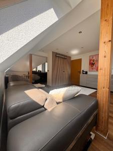 a black couch in a room with a ceiling at Design Dachgeschoss Wohnung in Eilenburg