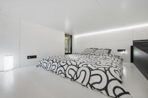 a white bedroom with a black and white bed at Relax al Mare with sauna near the sea in Laulasmaa