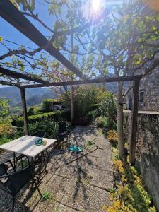 a table and chairs sitting under a wooden pergola at Le Coccinelle in Pallerone