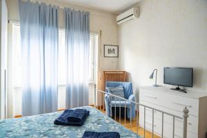 a bedroom with a bed and a tv and a chair at AppleCat in Rome