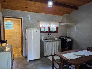 a kitchen with a refrigerator and a table in it at Recanto Manacá- Monte Verde in Camanducaia +18 photos