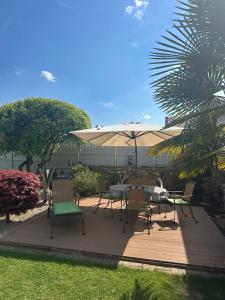 a patio with a table and chairs and an umbrella at Ferienwohnung Riva in Kronau