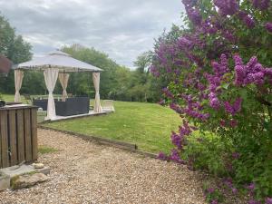a garden with a gazebo and purple flowers at Gite de Sainte Gemme in Sainte-Gemme