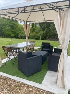a patio with a table and chairs under a canopy at Gite de Sainte Gemme in Sainte-Gemme
