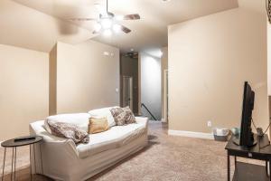 a living room with a white couch and a ceiling fan at Osile Villa in DeSoto