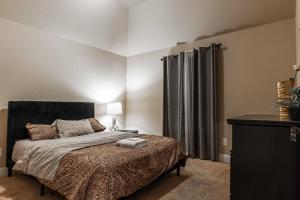 a bedroom with a bed with a black headboard and curtains at Osile Villa in DeSoto