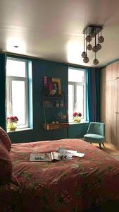 a bedroom with a bed and a chair and windows at Lola des Sources in Spa