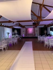 a banquet hall with white tables and white chairs at Chambres à 2 pas du Mans in Trangé