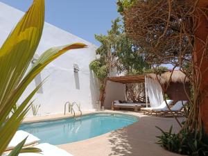 a swimming pool in the middle of a yard at Maison Talouma in Saly Portudal