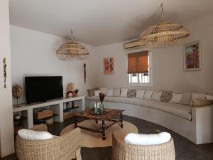 a living room with a couch and chairs and a tv at Maison Talouma in Saly Portudal