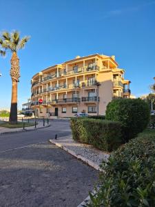 a building with a palm tree in front of a street at 2 bed appartment, close to the beach in Albufeira