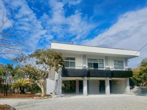 a white house with a balcony on top of it at Hope Private Villa tateyama in Tateyama
