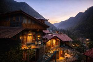 a house in the mountains with the lights on at Foresta Living Kasol in Kasol