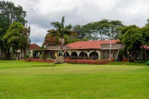 a golf course with a house and a green at Nyeri Club in Nyeri