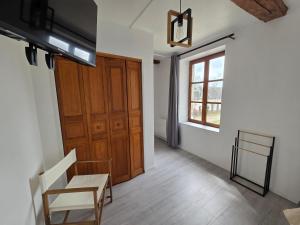 a room with a wooden door and a chair and a window at Haras de la Ressée in Agnez-lès-Duisans
