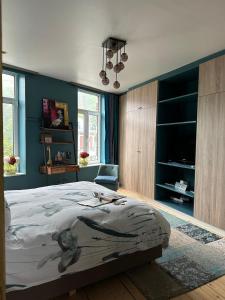 a bedroom with a large bed and a blue wall at Lola des Sources in Spa