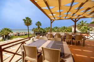 a patio with a table and chairs and the ocean at Sentinus Beach Hotel in Kuşadası