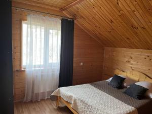 a bedroom with a bed in a wooden cabin at Тростян та річка in Slavske