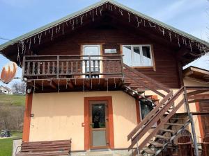 a wooden house with a balcony and a staircase at Тростян та річка in Slavske