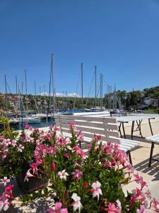 a group of benches and flowers in front of a marina at Apartments Dora, with a beautiful view of the bay, near the sea and center in Vrboska