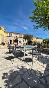 a table and chairs sitting on a patio at Qća Krk Apartments in Dobrinj