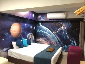 a bedroom with a space themed wall at 48 Ville Donmuang Airport in Bangkok
