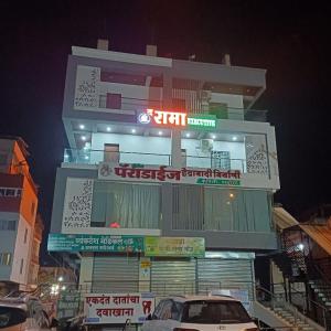 a building with a car parked in front of it at THE RAMA Executive in Tuljapur