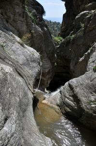 a stream of water in a canyon with rocks at Xenos Apartments in Keratokampos