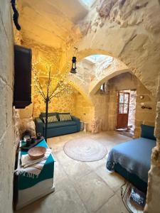 a living room with a bed and a couch at L'Artiste Guest House in Xagħra