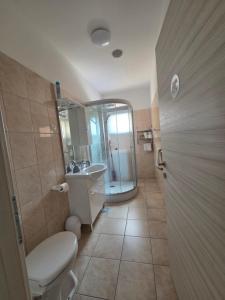 a bathroom with a toilet and a sink and a shower at Apartments Dora, with a beautiful view of the bay, near the sea and center in Vrboska +36 photos