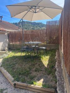a table and chairs with an umbrella in the yard at la petite colline in Cavaillon