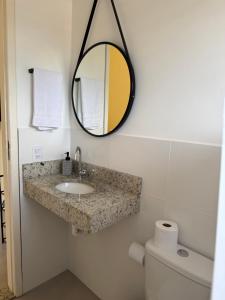 a bathroom with a sink and a mirror on the wall at Suíte confortável no centro da cidade in Miguel Pereira +5 photos