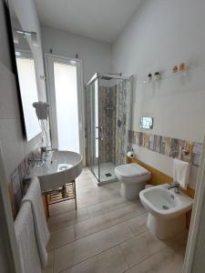 a bathroom with two sinks and a toilet and a shower at Bilateral B&B in Avola +45 photos
