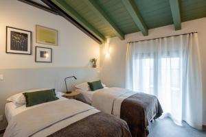 two beds in a room with a window at Vigne del Malina - Agriturismo & Winery in Orzano