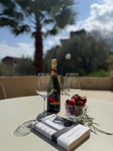 a bottle of wine and two glasses on a table at Villa Annunziata Superior in Aragona