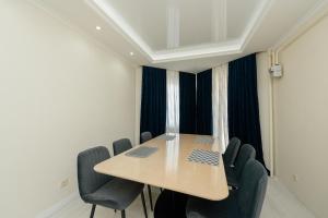 a conference room with a wooden table and chairs at ERA RENT Apartments in Chişinău