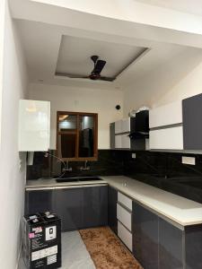 a kitchen with black and white cabinets and a ceiling at Aanya Bnb in Zirakpur