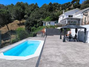 a swimming pool with an umbrella next to a house at Espacio Kybalion in Argentona
