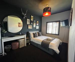 a bedroom with a bed and a vanity and a mirror at Comfortable Room or Whole House - 4BR 1BATH 1TOILET at Suffolk Pink House, Newmarket in Newmarket +30 photos
