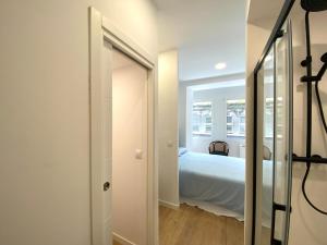 a white room with a bed and a mirror at El Patio de María in Ferrol