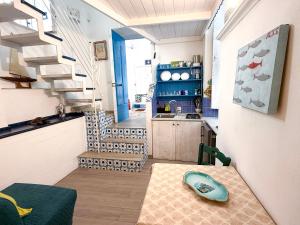 a room with a table and a kitchen with stairs at Il Moscardino in Vico Equense