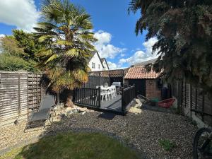 a backyard with a fence and a palm tree at Comfortable Room or Whole House - 4BR 1BATH 1TOILET at Suffolk Pink House, Newmarket in Newmarket
