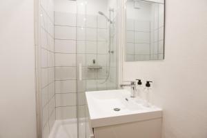 a white bathroom with a sink and a shower at Maison avec parking la Flocellière in La Flocellière +15 photos