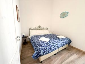 a bedroom with a bed with a blue and white comforter at Il Moscardino in Vico Equense