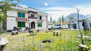 a building with a yard with chairs and a table at North Paradise Guest House in Skardu