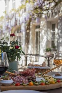 a plate of food on a table with a glass of wine at Le clos aux roses in Chédigny